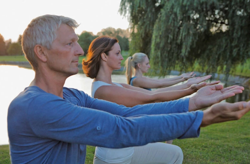 Eine Gruppe Menschen macht Qigong im Park